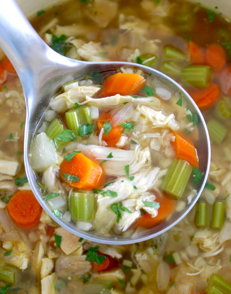 Keto Chicken Soup with Cauliflower Rice in silver ladle held over pot