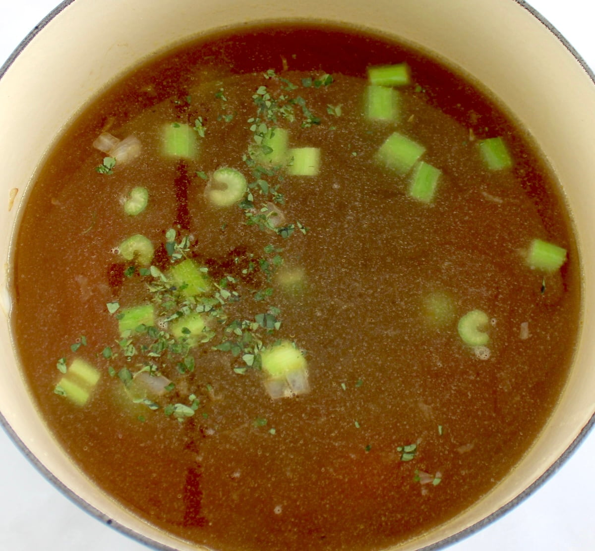 chicken broth, onions celery and carrots in pot