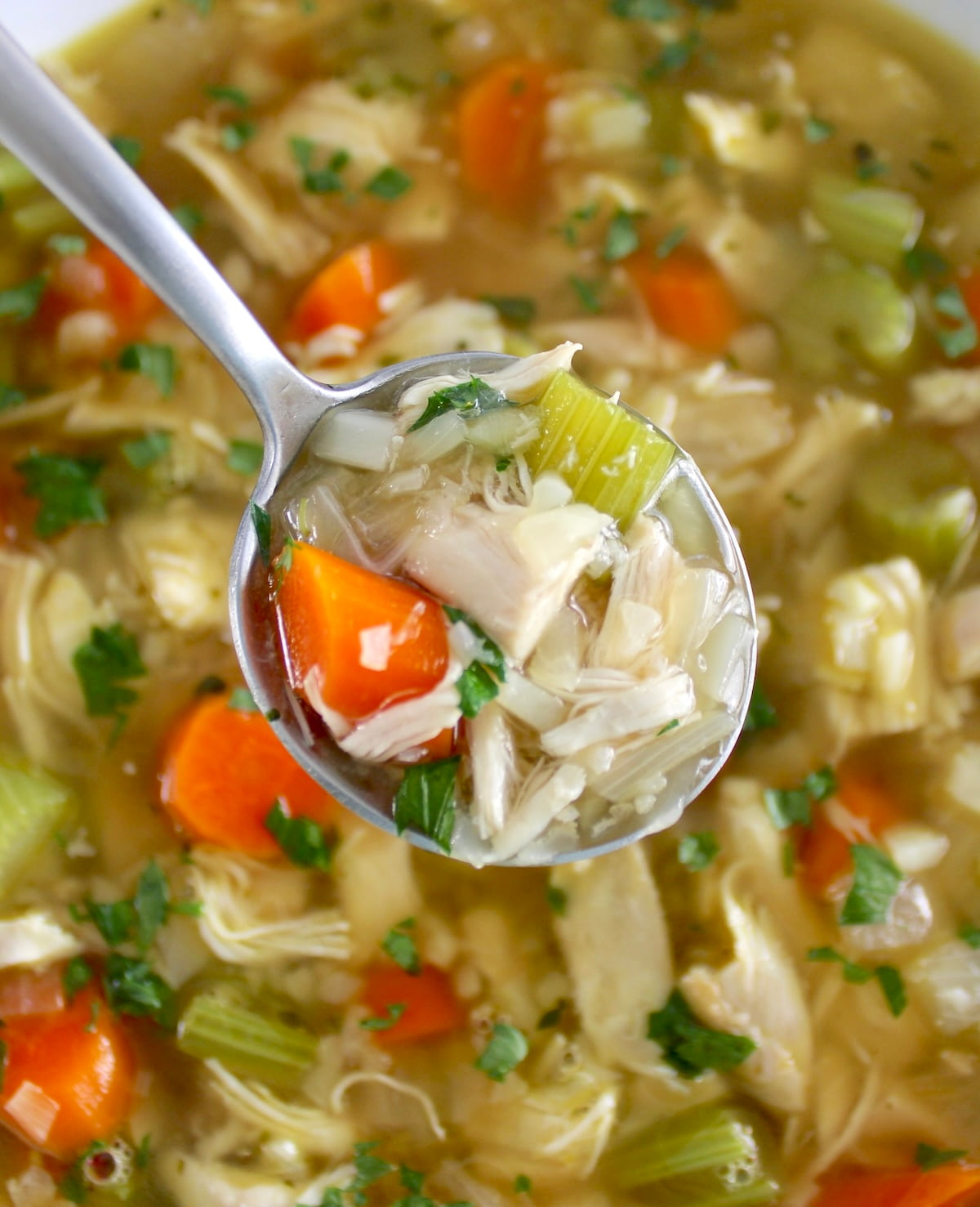Keto Chicken Soup with Cauliflower Rice in spoon held over bowl
