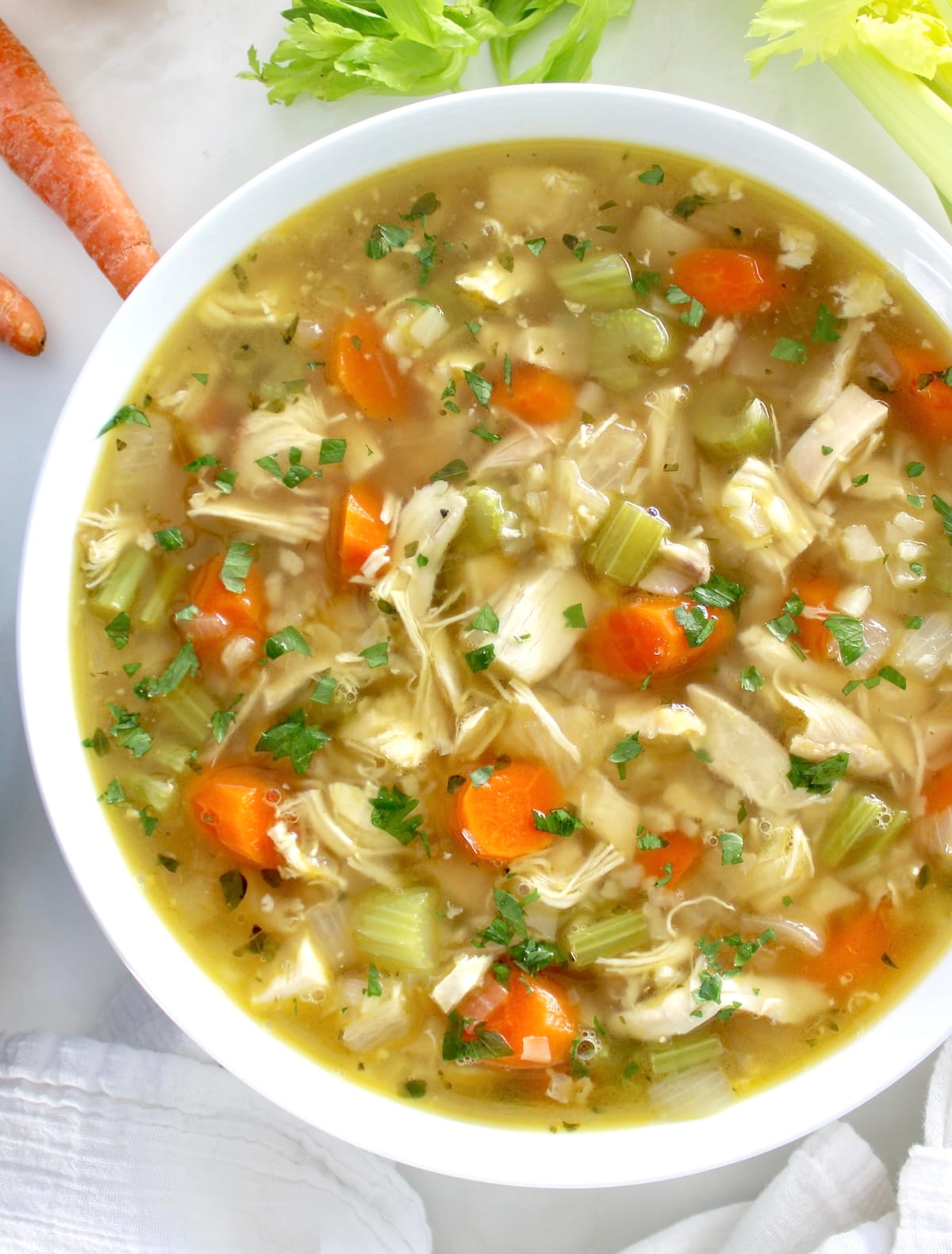overhead view of Keto Chicken Soup with Cauliflower Rice in white bowl