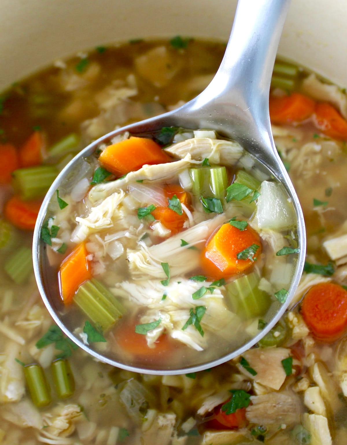 ladle full of Keto Chicken Soup with Cauliflower Rice held up over pot