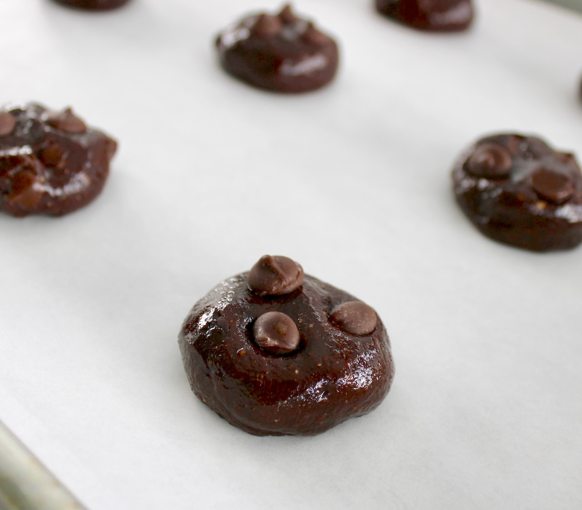 Keto Chocolate Almond Butter Cookie dough balls on baking sheet lined with parchment paper