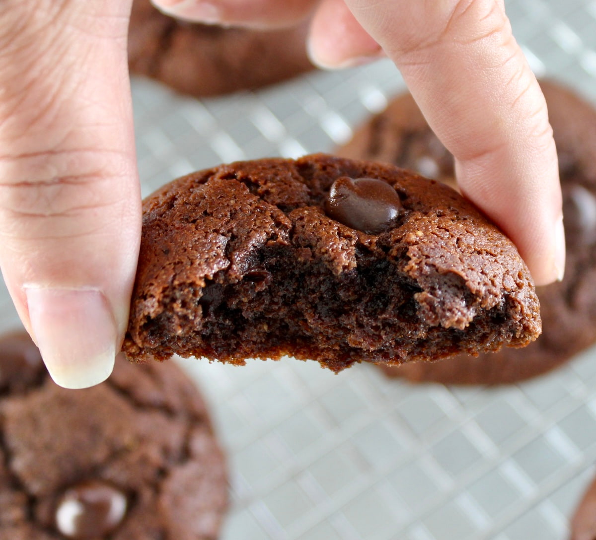 holding up Keto Chocolate Almond Butter Cookie with bite missing