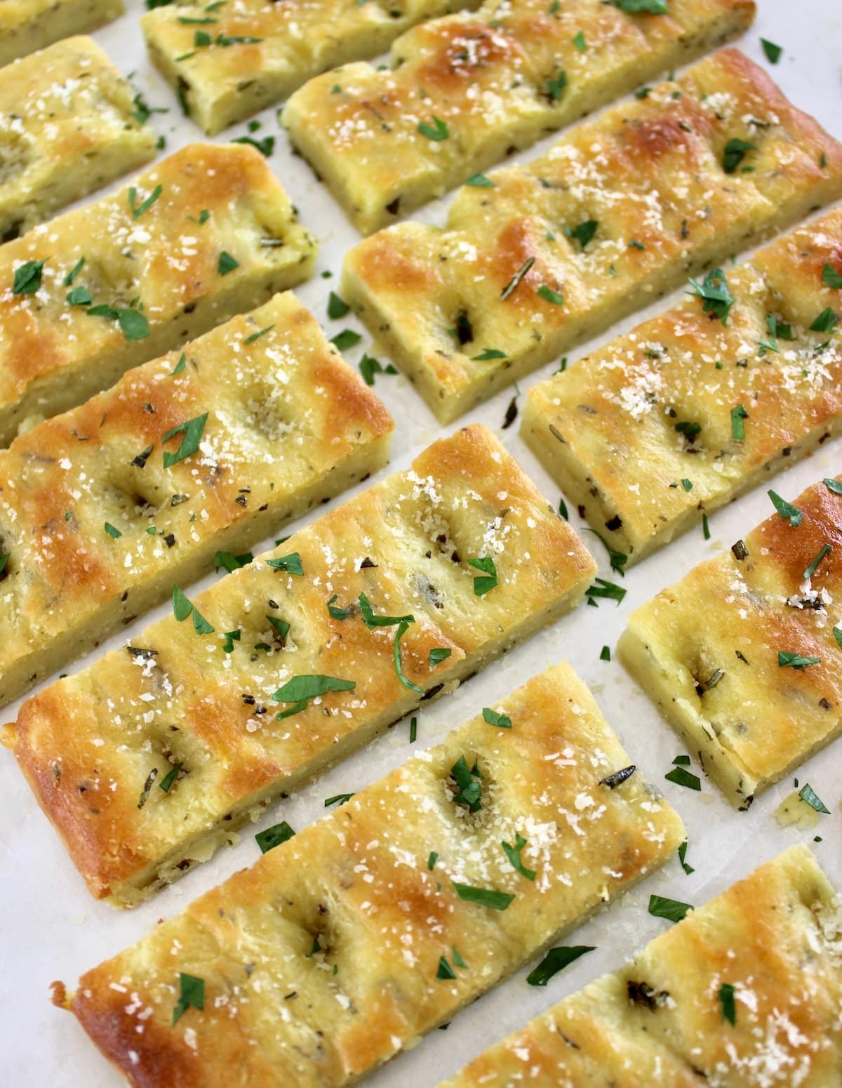 overhead view of Keto Focaccia Breadsticks on white parchment paper