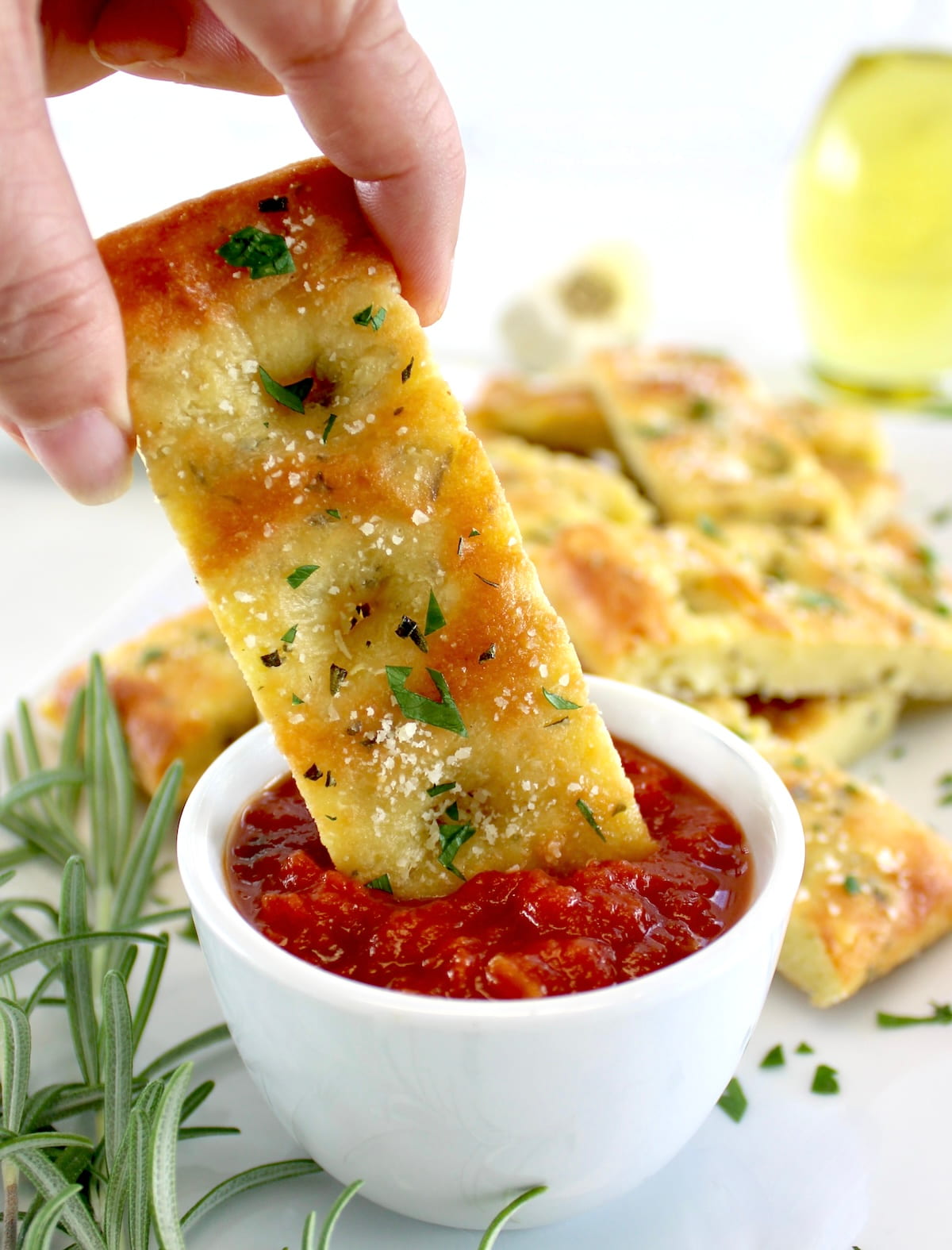 dipping Keto Focaccia Breadstick into marinara sauce