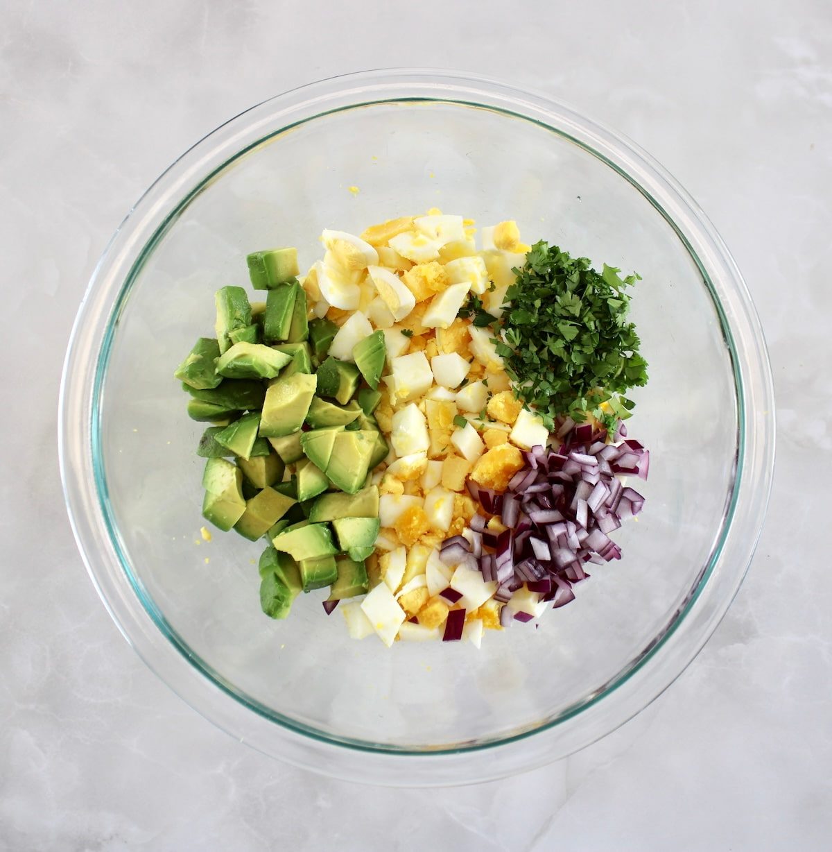 Avocado Egg Salad ingredients in glass bowl unmixed