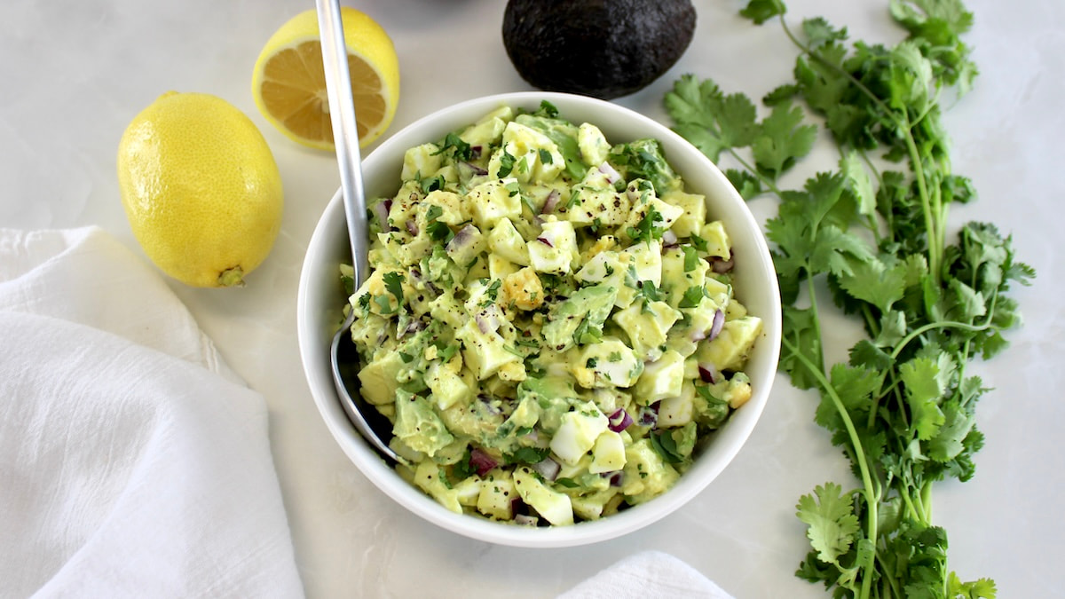 Avocado Egg Salad in white bowl with spoon on side