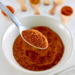 Homemade Chili Seasoning in spoon held up over white bowl