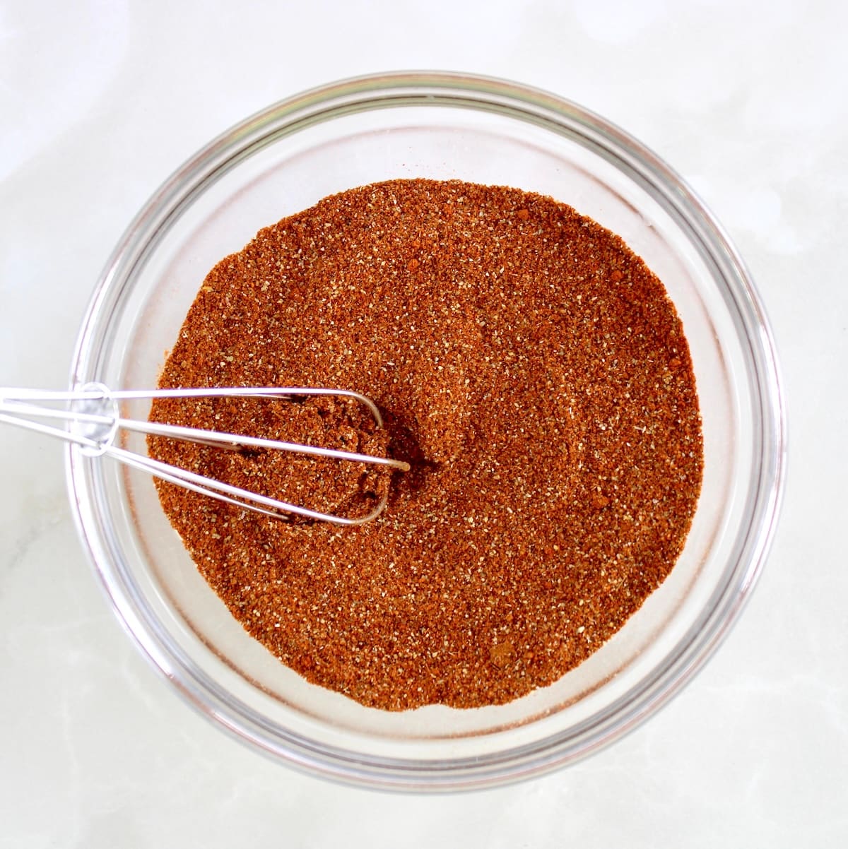 Homemade Chili Seasoning in glass bowl with whisk
