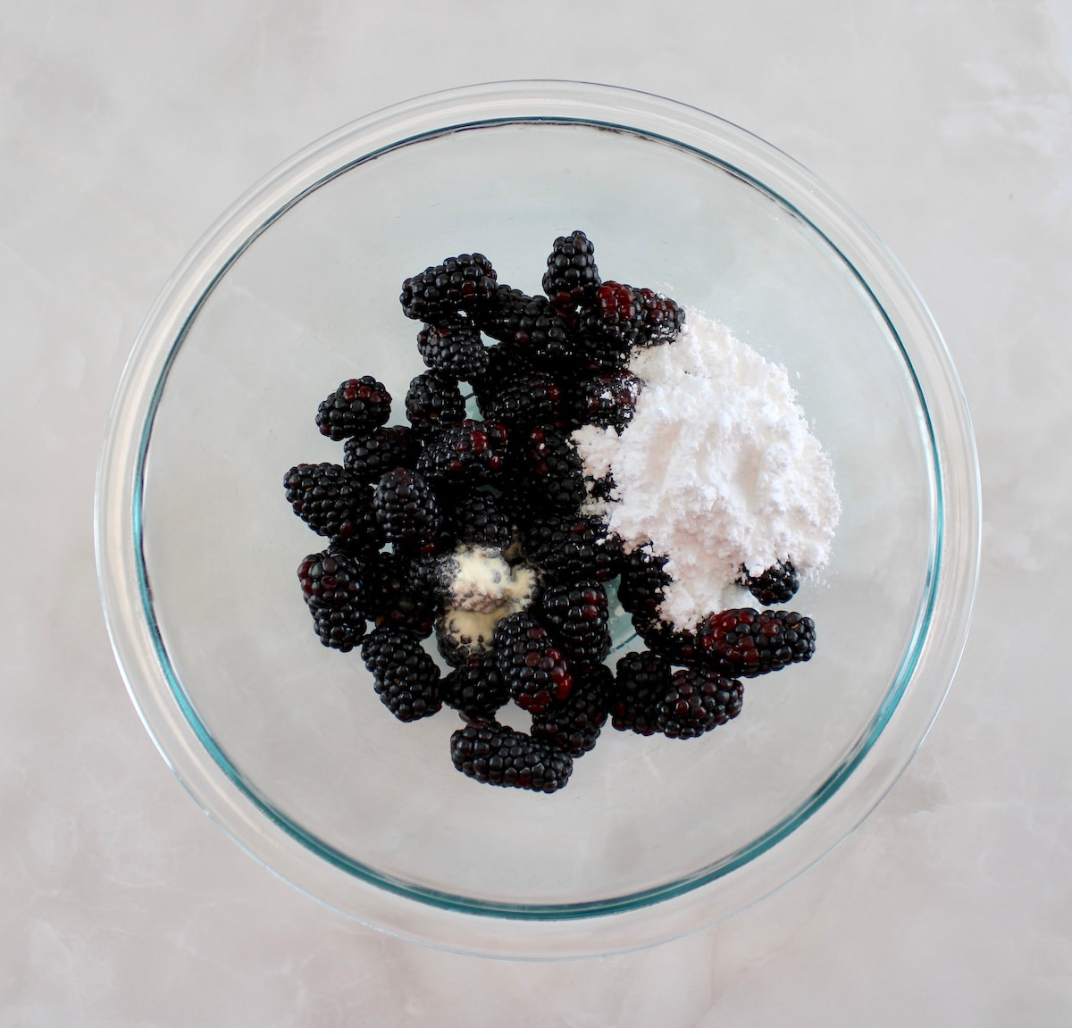 blackberries with sweetener on top in glass bowl