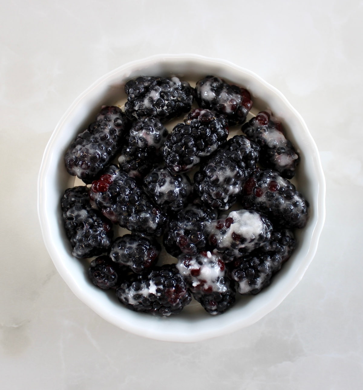 blackberries mixed with sweetener in white ramekin