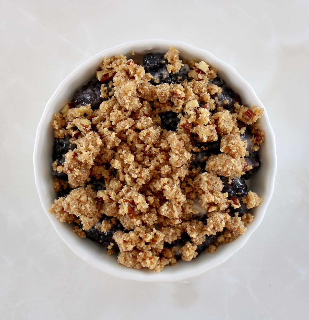 Keto Blackberry Crumble in white ramekin unbaked