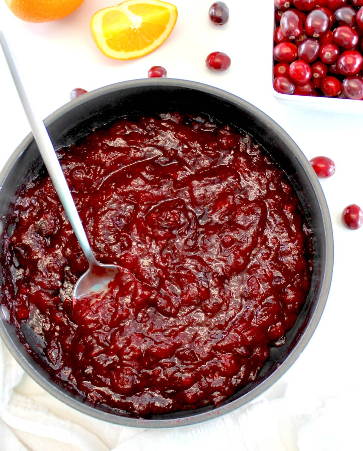 overhead view of Keto Cranberry Sauce in saucepan with spoon