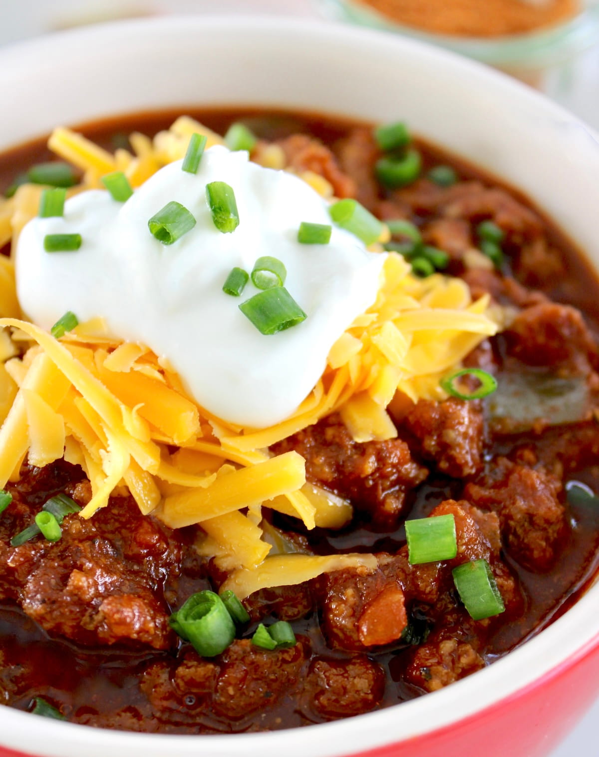 overhead view of Keto Instant Pot No-Bean Chili with shredded cheddar and sour cream on top