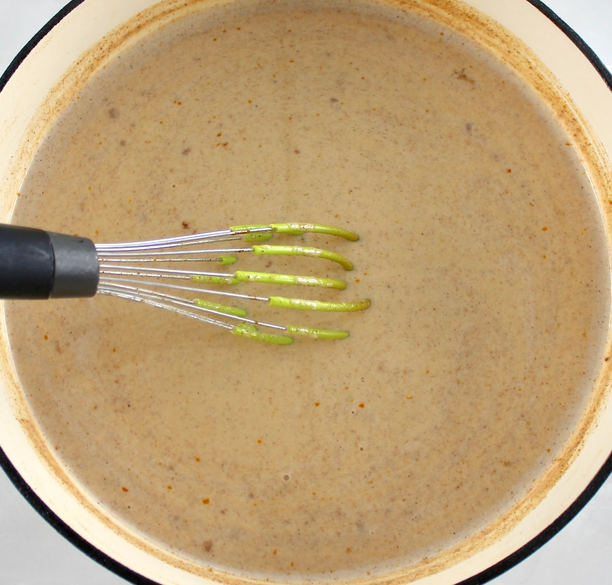 Keto Pumpkin Spice Coffee Creamer in skillet with whisk