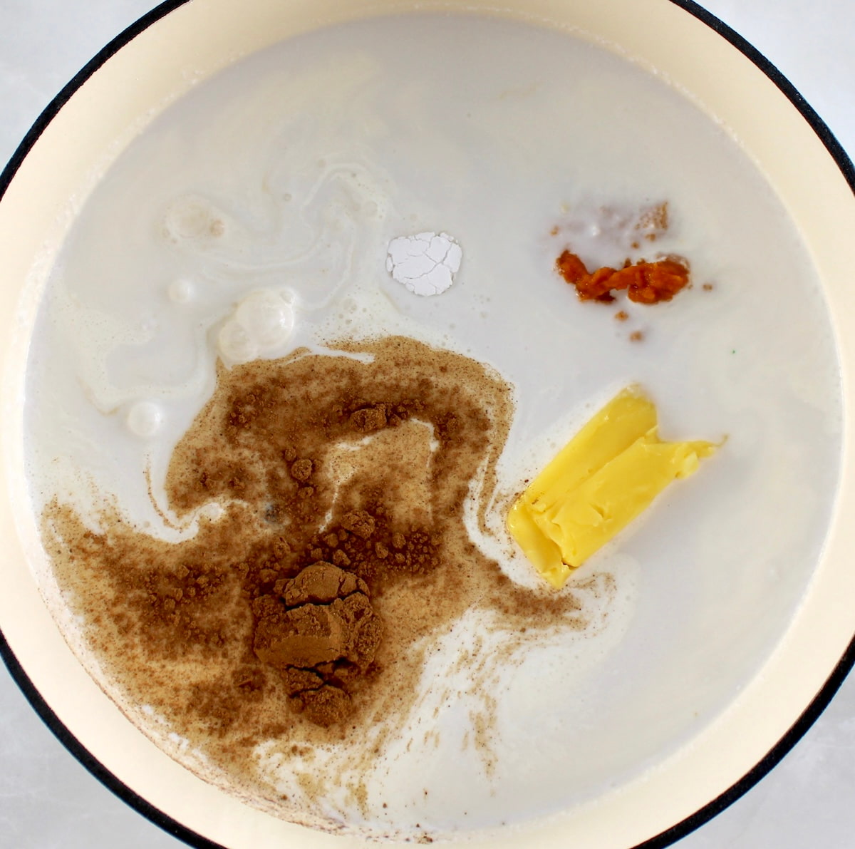 Keto Pumpkin Spice Coffee Creamer ingredients in skillet unmixed