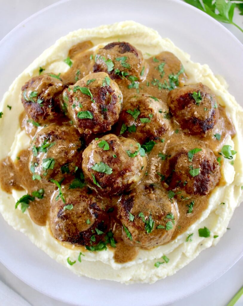 Keto Swedish Meatballs over cauliflower mash with parsley on top