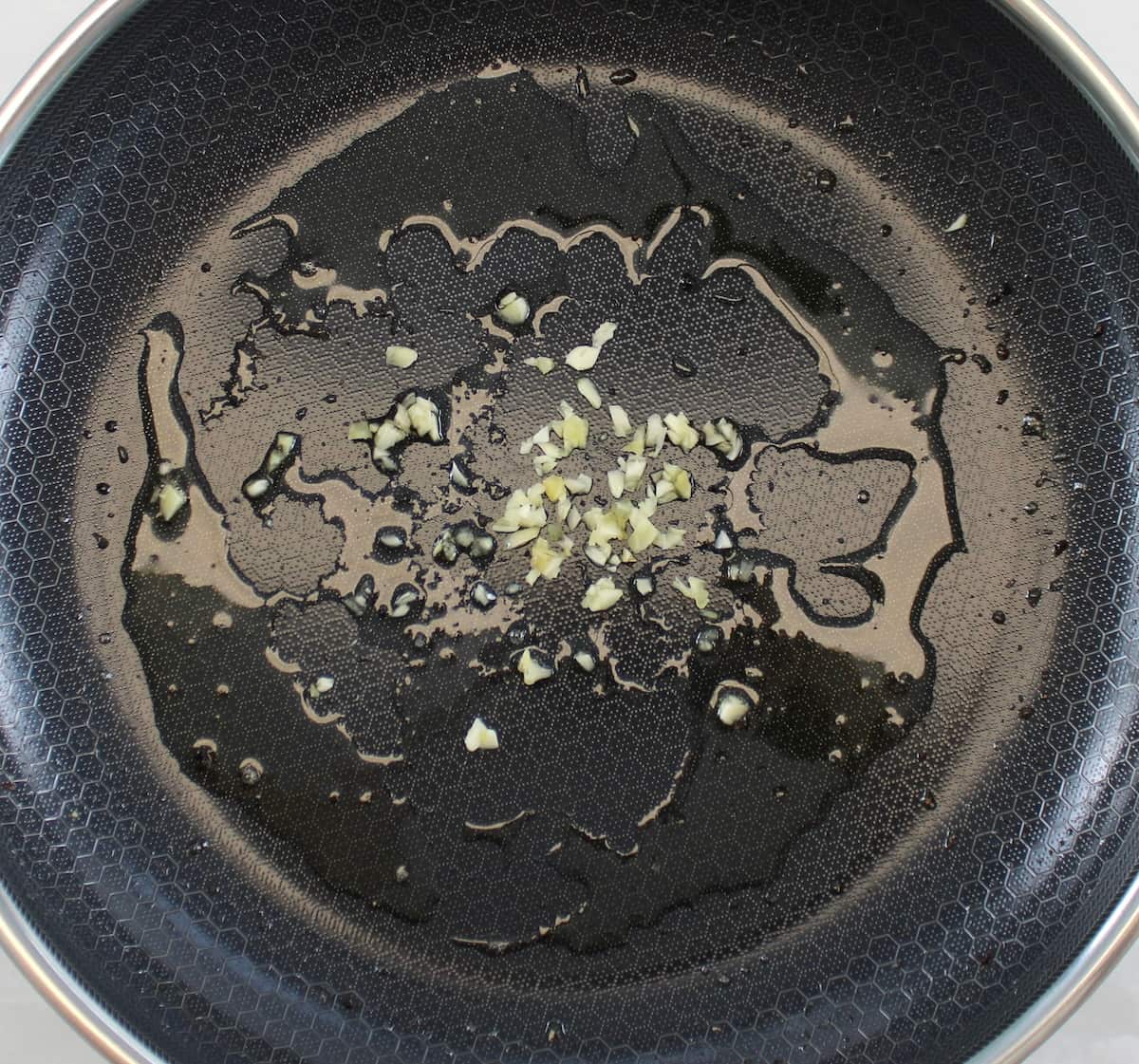 minced garlic sautéing in skillet