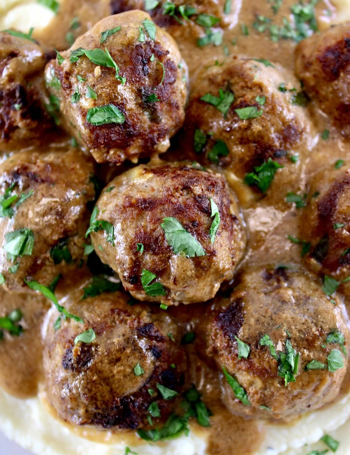 closeup of Keto Swedish Meatballs over mashed cauliflower with gravy