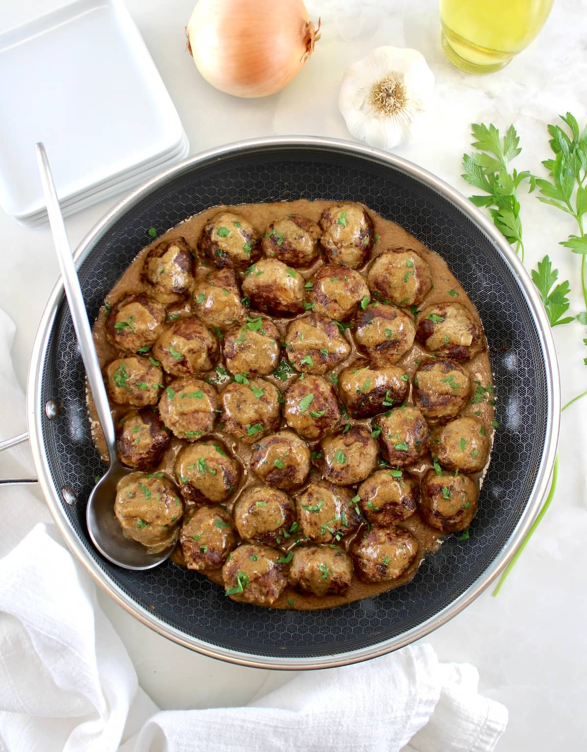 Keto Swedish Meatballs in skillet with serving spoon on side
