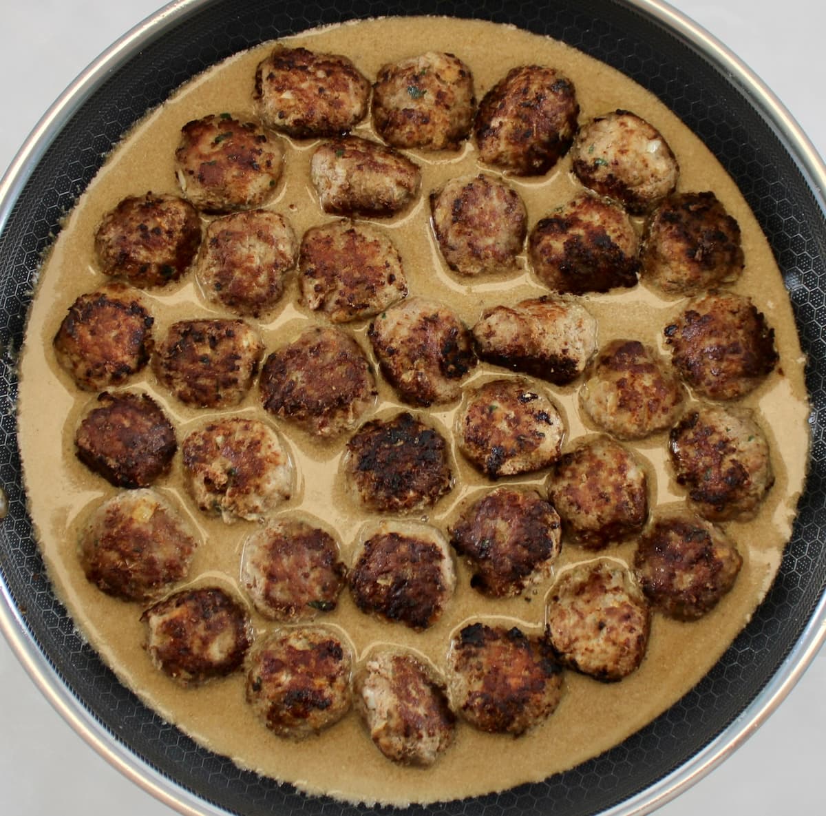 Keto Swedish Meatballs in gravy cooking in skillet
